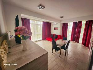 a living room with a table and a vase of flowers at Luxury ApartHotel Alezzi Spa Resort Piscina Incalzita in Mamaia Nord