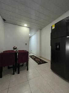 a room with a table and a black refrigerator at Guatavita Loft - Apartamento in Guatavita +1 photo