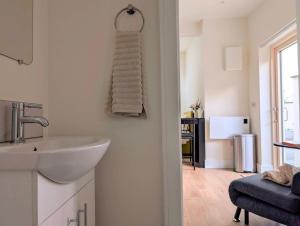 une salle de bains avec un lavabo et une serviette accrochée au mur dans l'établissement Garden Apartment with Private Entrance, à Dublin 2 autres photos