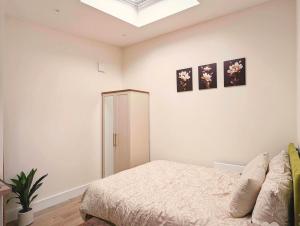 une chambre avec un lit et deux tableaux au mur dans l'établissement Garden Apartment with Private Entrance, à Dublin