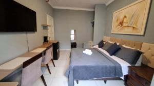 Un dormitorio con una cama y un televisor de pantalla plana. en Quarto Plus Gonzaga, en Santos