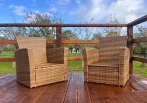 two wicker chairs sitting on a wooden deck at The Apple Rest in Snitterfield