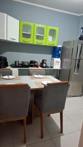 Una cocina con mesa y sillas y un refrigerador. en Quarto Plus Gonzaga, en Santos
