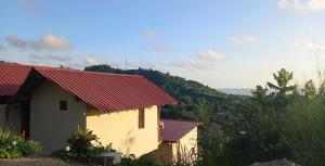 een klein huis met een rood dak op een heuvel bij Bungalows Ayampe in Ayampe