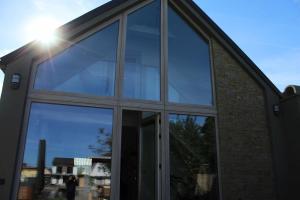 una gran ventana de vidrio en el costado de un edificio en Luxus Vendégház a Szigetköz szívében, en Dunasziget