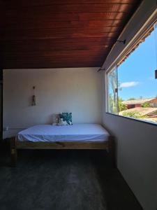 een bed in een kamer met een raam bij Pousada Zen Caraiva in Caraíva