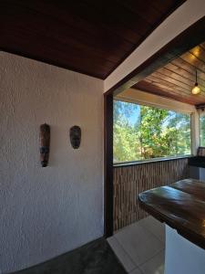 een kamer met een tafel en een raam in een huis bij Pousada Zen Caraiva in Caraíva