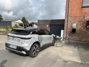 een witte auto laadt op een parkeerplaats bij Kanal 33 in Schafstedt