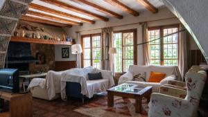 a living room with couches and a tv at Mas de Paco, Chimenea, barbacoa y piscina in Vall dʼAlba