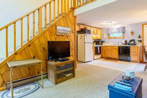 a living room with a staircase and a kitchen at Moose’in Around in Sweden