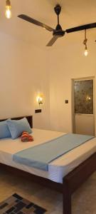 a bedroom with a bed with a ceiling fan at Sulo House in Weligama