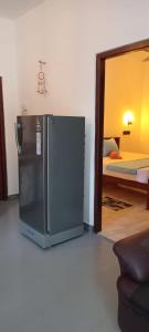 a black refrigerator in a room with a bedroom at Sulo House in Weligama