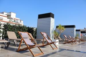 a row of lounge chairs sitting on a patio at BCN MONTJUÏC Apartments in Barcelona