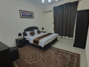 a bedroom with a large bed and a rug at العييري للشقق المخدومة حائل 3 in Hail