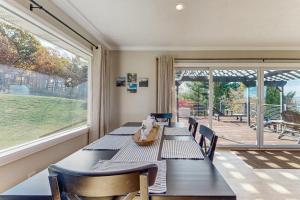 BurdettにあるSeneca Lake Overlook - Unit Aのテーブルと椅子と大きな窓のあるダイニングルーム