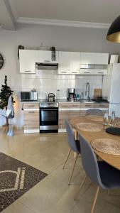 kuchnia z białymi szafkami, stołem i krzesłami w obiekcie DiDi Apartament Centrum w Nowym Targu +17 zdjęć