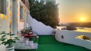 a white building with a green floor and stairs at Go Inn Backpackers in Aswan