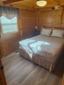 a bedroom with a bed in a wooden cabin at Mammoth Cave Accommodation for a Kentucky Glamping Experience in Mammoth Cave +9 photos