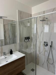 a bathroom with a shower and a sink at OFF 32 Suites in Melzo +17 photos