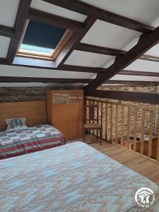 een slaapkamer met een bed en een dakraam bij Rossignol in Le Bez