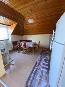 eine Küche mit Tisch und Stühlen und einem Kühlschrank in der Unterkunft Three-Bedroom Apartment in Gyenesdias I in Gyenesdiás