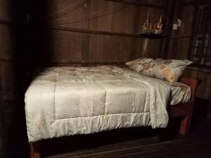 a bedroom with a bed with a white comforter at Sconvolt Homestay in Kratie