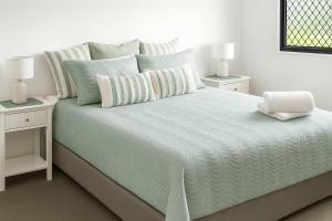 1 cama blanca con 2 mesitas de noche y 2 lámparas en Paradise on Palmer-City Stadium Ferry&Strand in Townsville, en Townsville