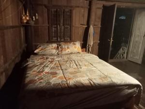 a bedroom with a bed with a comforter on it at Sconvolt Homestay in Kratie