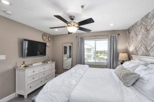 a bedroom with a white bed and a ceiling fan at Commodore's Retreat 305 in Seagrove Beach +26 photos