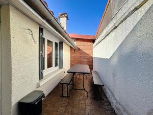 a patio with a bench and a table and a window at Maison 7 personnes Quartier Oradou Pardieu in Clermont-Ferrand