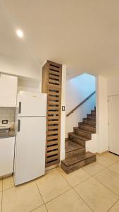 a kitchen with a white refrigerator and a staircase at Los Carpinchos: Duplex in Federación