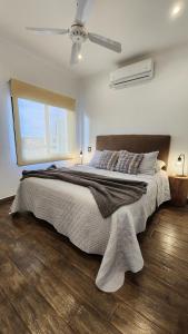 a bedroom with a large bed with a ceiling fan at Los Carpinchos: Duplex in Federación +53 photos