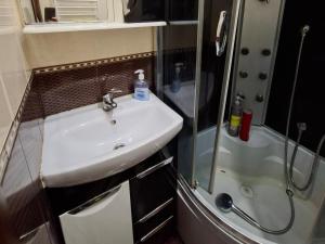 ein Badezimmer mit Waschbecken und Dusche in der Unterkunft Comfort apartment in Krywyj Rih
