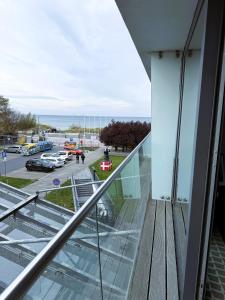 einen Glasbalkon mit Blick auf einen Parkplatz in der Unterkunft ABSea Marine Hotel Apartament z widokiem na morze in Kołobrzeg