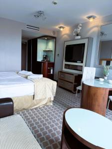 ein Hotelzimmer mit zwei Betten und einem Flachbildfernseher in der Unterkunft ABSea Marine Hotel Apartament z widokiem na morze in Kołobrzeg