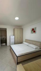 a bedroom with a large bed and a refrigerator at Almare Apartments in Vlorë