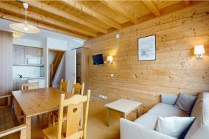 un salon avec une table et un canapé dans l'établissement Les Arolles - La Plagne 1800, à La Plagne Tarentaise
