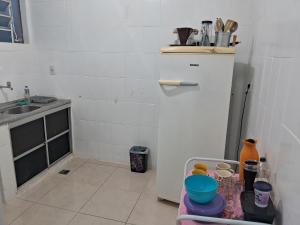 une petite cuisine avec un évier et un réfrigérateur dans l'établissement Apto 2 quartos Grã Duquesa, à Governador Valadares