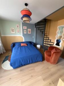 a bedroom with a blue bed and a chair at Cozy House in Yvetot
