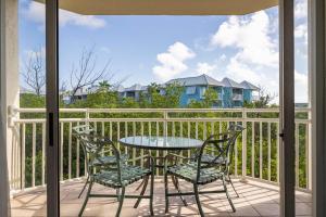 a patio with a table and chairs on a balcony at Tortuga Suite at Sunrise Suites Resort - Heated Pool, Hot Tub & Free Parking in Key West