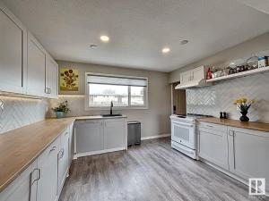 eine große Küche mit weißen Schränken und einem Fenster in der Unterkunft UofA Bike Lane-Train-Bus- Southgate Mall, Cental in Edmonton