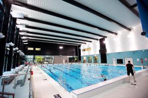 a large swimming pool with a man standing in front of it at Guest Rooms at Lancaster University in Lancaster