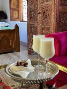 a table with two glasses and a plate of food at Dar Chama in Chefchaouene