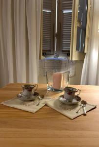 萨萨里Campus room的一张桌子上放着两个杯子、两把勺子和一支蜡烛。