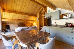 PelvouxにあるChalet Le Chastelの木製のテーブルと椅子のあるキッチンとダイニングルーム