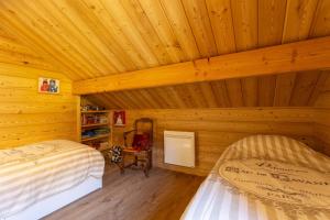 PelvouxにあるChalet Le Chastelの丸太小屋のベッドが2つある寝室