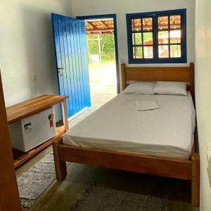 a bedroom with a bed and a door with a window at Pousada Trincheira in Ilha Comprida +12 photos