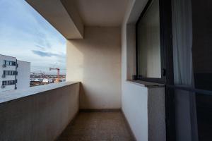 un balcón vacío de un edificio con una puerta abierta en Ivory Garden Retreat by Blvd 60B2 - Luxury Apartment in Voluntari, en Voluntari