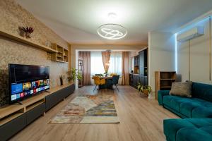 Una sala de estar con un sofá azul y un televisor en Ivory Garden Retreat by Blvd 60B2 - Luxury Apartment in Voluntari, en Voluntari