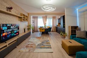 Una sala de estar con televisión y un comedor. en Ivory Garden Retreat by Blvd 60B2 - Luxury Apartment in Voluntari, en Voluntari